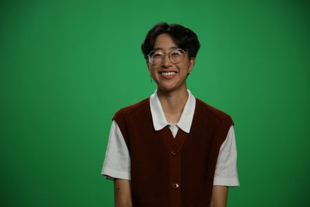A-Bel Gong sitting and smiling Infront of green screen. (National Geographic/Robert Toth)