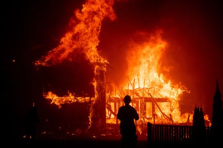 A home burns as the Camp Fire rages through Paradise, CA on Thursday, Nov. 8, 2018. (Photo by Noah Berger)