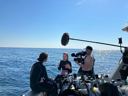 BTS of Diva Amon speaking with Tanya Houpperman on the Tiger Shark charter boat. (National Geographic/Verity Thomson)