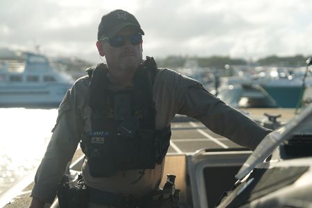 A CBP Agent stands on a water vessel with the ocean behind him in Mayaguez, P.R. (Lucky 8 TV/Paul Taggart)