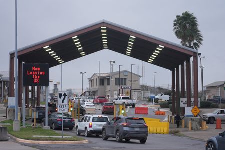 Multiple vehicles wait in line to cross the border in Brownsville, Texas. (National Geographic)