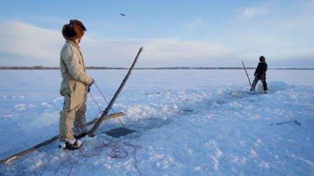 Gage and Avery Hoffman stop to look at an eagle flying over them while they set their fish net. (BBC Studios/Danny Day)