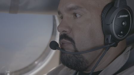 CBP AMO Agent Perez looks at a digital map from a helicopter  in Mayag¸ez, P.R.. (Lucky 8 TV/Paul Taggart)