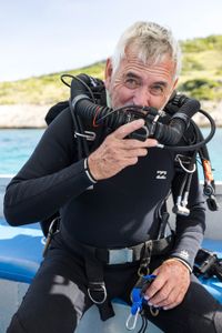 Cinematographer, Rory McGuinness, preparing his CCR to dive and film Day octopus (Octopus cyanea) on the Great Barrier Reef.   (photo credit: National Geographic/Harriet Spark)
