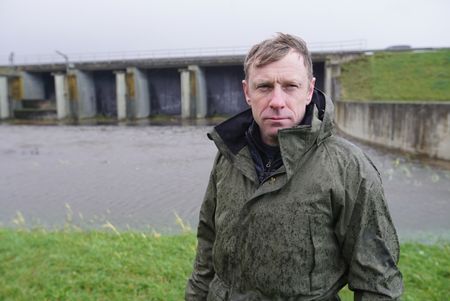 Andy Torbert stands outside a damn on the Ijssel Line. (National Geographic/Ciaran Henry)