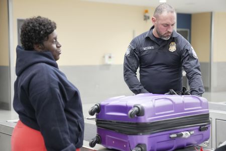 CBP Officer Mccants questions a passenger while going through their belongings in Atlanta, Ga. (National Geographic)