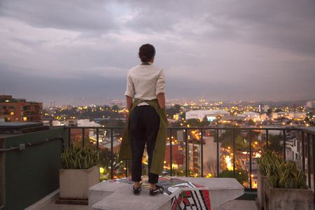 Chef Debbie Fadul looks out at the Guatemala City skyline from the balcony of her restaurant Diacá. The name is a twist on the Spanish, "de acá" which means "from right here" in that language. A classically trained chef, Debbie decided to work in Guatemala rather than abroad, in order to celebrate her country's heritage through food. (National Geographic/Adnelly Marichal)