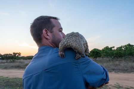 Giles Clark and Archie the baby pangolin. (National Geographic/Mark Challender)