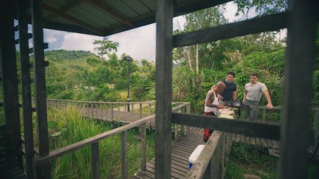 Peter, Henry Golding and Antoni Porowksi preparing Semah fish in the Jungle. (National Geographic)