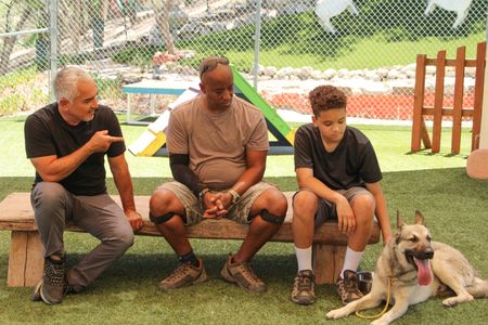 Cesar, Brandon, and Jackson sitting on a bench with a dog next to them. (National Geographic)