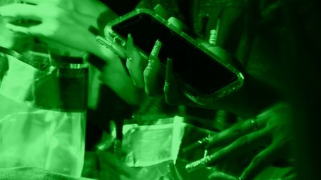 A suspect puts their cell phone in an evidence bag after they were caught attempting to cross the border illegally in the Rio Grande Valley, Texas. (National Geographic)