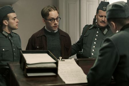 A SMALL LIGHT - Jan Gies, played by Joe Cole, is brought to the police station by German soldiers as seen in A SMALL LIGHT. (Credit: National Geographic for Disney/Dusan Martincek)