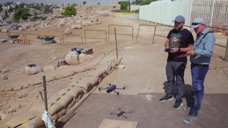 Felix Wolter and Raad Abu Alhaj work with a professional drone in Amman, Jordan. The drone lifts off the ground to undertake 3D mapping of the Citadel site. (Windfall Films)