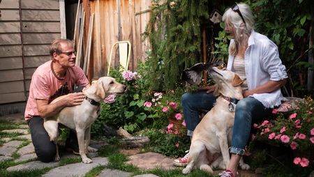 Conrad Anker and Jenni Lowe Anker play with their dogs and chickens in the yard.   (National Geographic/Elena Gaby)
