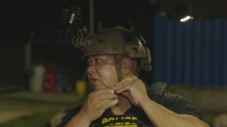 CBP AMO agent Andujar gears up and straps on his helmet in Fajardo. P.R. (Lucky 8 TVIvan Leon)