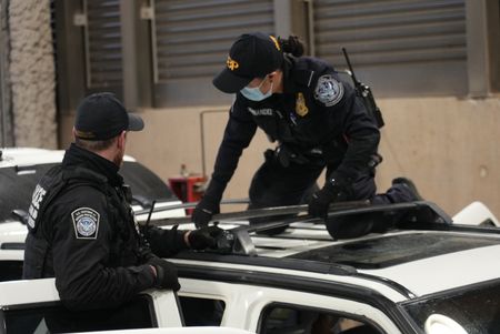 CBP Officers Hernandez and Hoffman work to dismantle the roof rack on a suspect's vehicle in search of smuggled drugs in Calexico, Calif. (National Geographic)