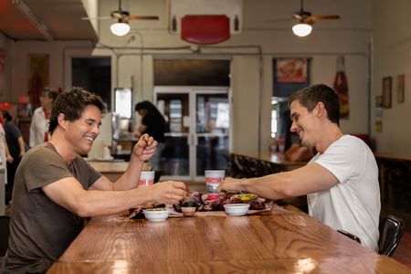 James Marsden and Antoni Porowski laugh over a shared plate of Texas barbecue. (National Geographic/Amy Mikler)