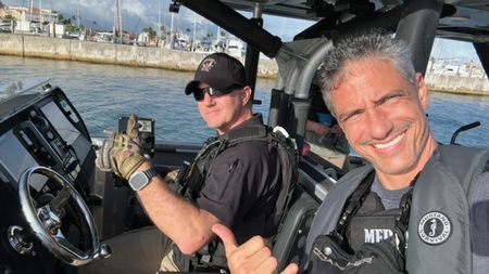 A cameraman takes a selfie photo with CBP AMO Agent Hud in Fajardo, P.R. (Lucky 8 TV/Paul Taggart)