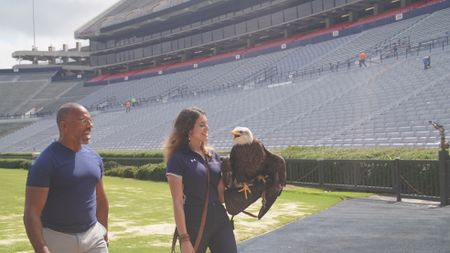 Christian Cooper assists rator trainer, Amanda Sweeney, with Independence's pre-gameday flight practice. (National Geographic for Disney)