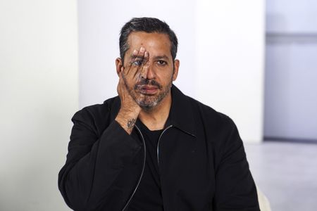 David Blaine poses with one hand painted as half of his face. (credit: National Geographic/Dana Hayes)