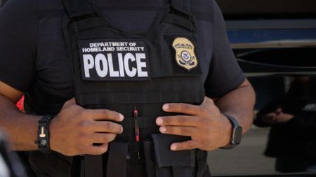 An HSI agent holds on to his bulletproof vest during a briefing on an operation that is about to be conducted in Miami, Fla. (National Geographic)