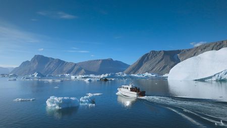 The team boat in the open water surrounded by icebergs.  (photo credit: National Geographic/Pablo Durana)