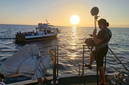 Sound technician and a party boat in the background in Ibiza, Balearic Islands. Spain. (National Geographic/Jose Antonio Gavilán Tobal)