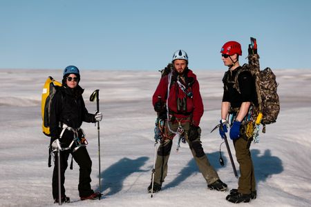 Melissa Marquez, Andreas Alexander, and PolarX guide Tom Lawton stand on a Svalbard glacier. (National Geographic/Mario Tadinac)