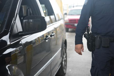 A CBP officer stands next to their booth at the Brownsville, Texas border, waiting to  inspect the next traveler's documents in Brownsville, Texas. (National Geographic)