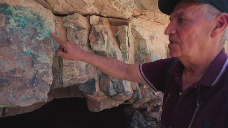 Jordanian archaeologist Mohammad Najjar points at an area at a former Copper mine in Wadi Faynan, Jordan.  (Windfall Films)