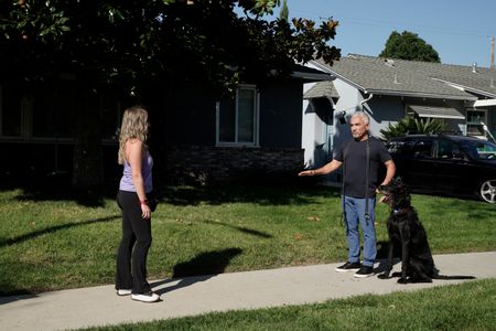 Cesar Millan standing with Lloyd while talking to Jaclyn. (National Geographic)