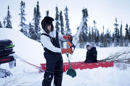 Ricko DeWilde using a chainsaw to cut a hole through the ice to set a beaver trap. (BBC Studios Reality Productions/v)