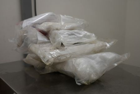 Multiple packages of suspected narcotics are placed on a scale to be weighed after they were found smuggled in a suspect's vehicle in Calexico, Calif. (National Geographic)