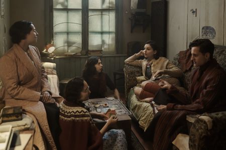 A SMALL LIGHT - The Frank, van Pels, and Gies families play a game of Monopoly in the secret annex, as seen in A SMALL LIGHT. (From left: Amira Casar as Edith Frank, Ashley Brooke as Margot Frank, Bel Powley as Miep Gies, Billie Boullet as Anne Frank, and Rudi Goodman as Peter van Pels). (Credit: National Geographic for Disney/Dusan Martincek)