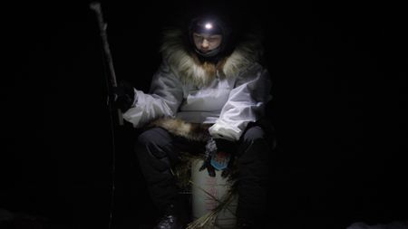 Qutan Hailstone ice fishing with her family at night. (BBC Studios/Dwayne Fowler)