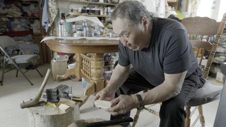 John Pingayak carving a bird out of wood for his grandchildren. (National Geographic/Matt Kynoch)
