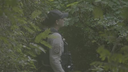 CBP AMO Agent Brittany wears a bulletproof vest while walking through a  forest looking for smugglers in St. Thomas, USVI. (Lucky 8 TV/Valery Lyman)