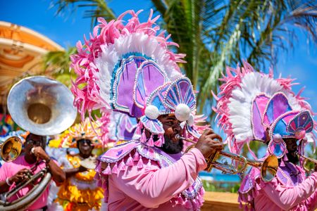 A performer plays a musical instrument while participating in a presentation  for guests on Lookout Cay at Lighthouse Point, The Bahamas. (Disney/Steven Diaz)