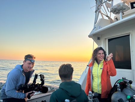 Diva Amon and crew laughing into camera on the Rockery Bay research boat. (National Geographic/Verity Thomson)