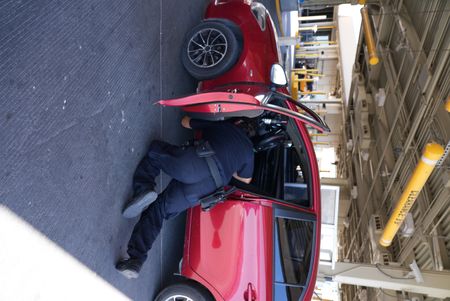 A CBP officer inspects the trunk of a passenger's vehicle for hidden contraband in El Paso, Texas. (National Geographic)