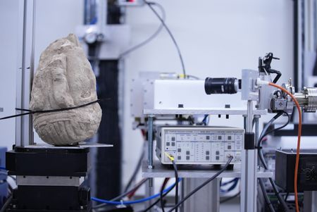 The stone head is scanned at the SESAME laboratory to find out further details about the recently unearthed sample. (Windfall Films/Alex Collinge)