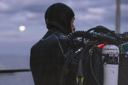Director and cinematographer, Adam Geiger, gearing up for a CCR night dive in Port Phillip Bay.  (photo credit: National Geographic/Harriet Spark)