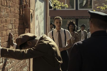 A teenage Malcolm X, played by Joshua Caleb Johnson, watches as police search a man as seen in GENIUS: MLK/X. (National Geographic/Richard DuCree)