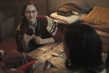 A SMALL LIGHT - Margot Frank, played by Ashley Brooke, plays monopoly with her family in the annex, as seen in A SMALL LIGHT. (Credit: National Geographic for Disney/Dusan Martincek)