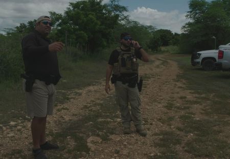 Two CBP Agents stand on a dirt road in Mayaguez, P.R. (Lucky 8 TV/Paul Taggart)