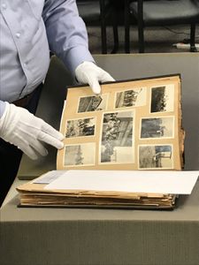 Dr. Brian Mitchell examines the scrapbook in the Research Room at the Arkansas State Archive. (National Geographic/Brandy Austin)