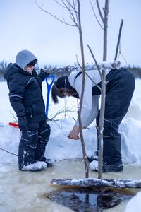 Ricko DeWilde teaches his son Keenan DeWilde how to properly set a beaver trap under the ice. (BBC Studios Reality Productions/v)