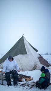 Agnes Hailstone shows her grandson Sabastian how to pluck ptarmigan, with the help of her husband, Chip Hailstone. (BBC Studios Reality Productions/Ashton Hurlburt)