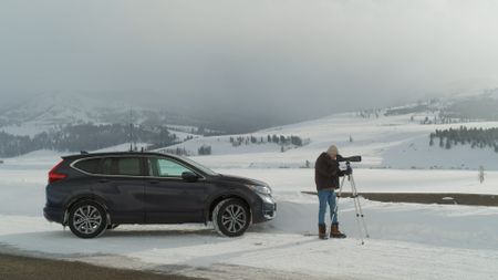 Naturalist and former Yellowstone Park Ranger Rick McIntyre looks for wolves using his telescope. (National Geographic/Rick Smith)