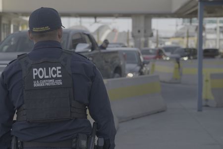 A CBP officer looks at the multiple lines of vehicles that are waiting to cross the border at the El Paso port of entry in El Paso, Texas. (National Geographic)